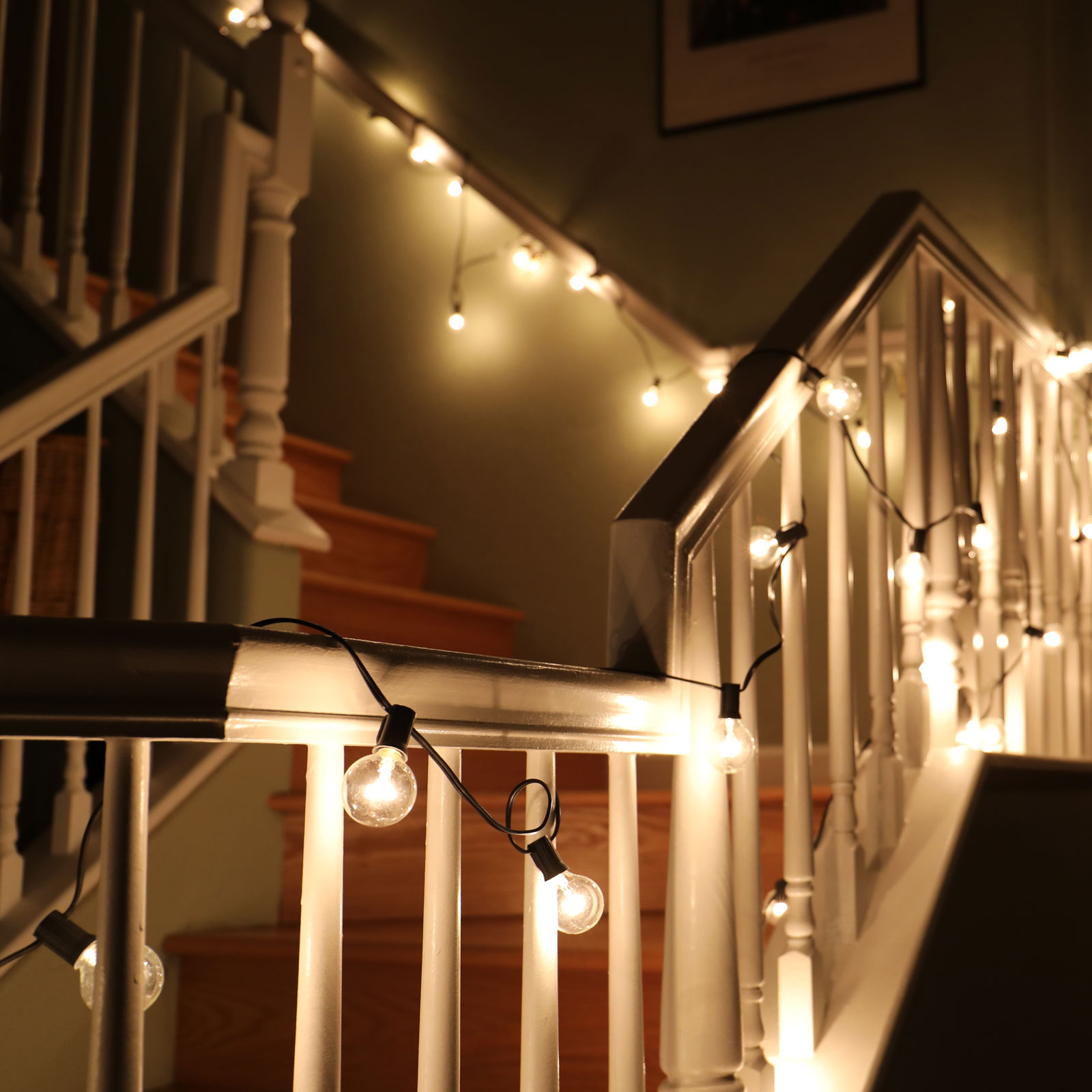 Corner staircase in home lit by string lights