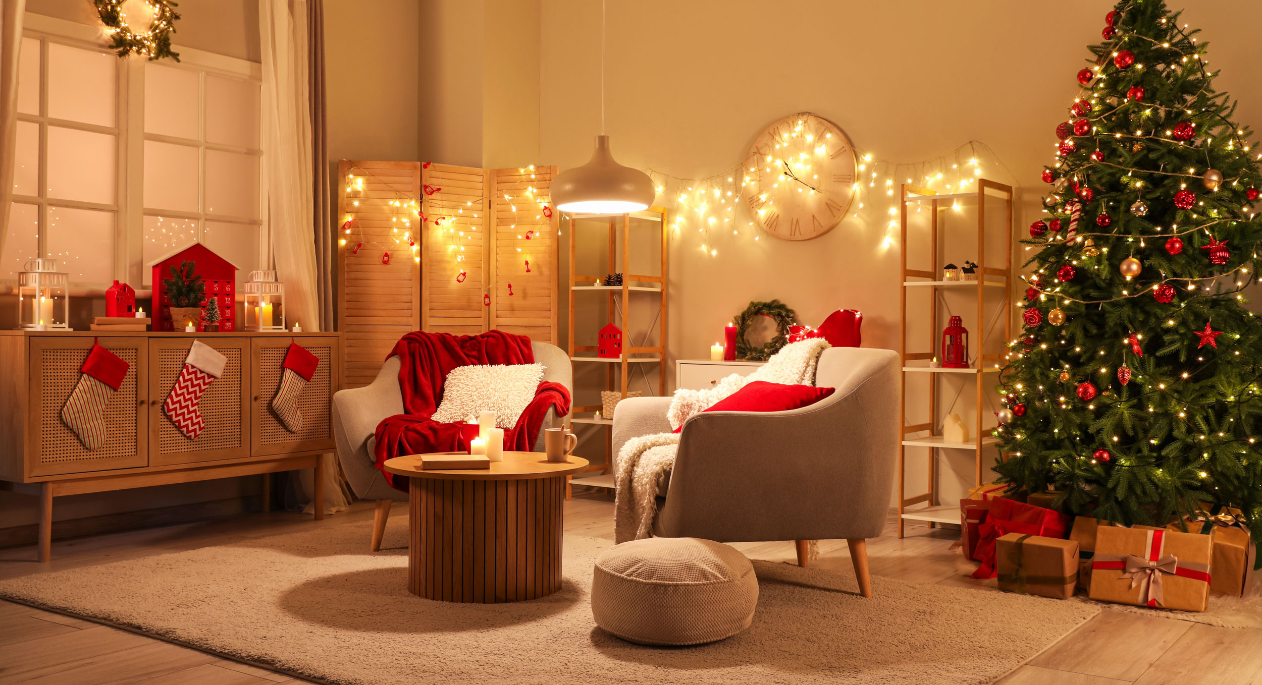 Photo of a cosy lounge with armchairs, a Christmas tree and lots of warm string lights